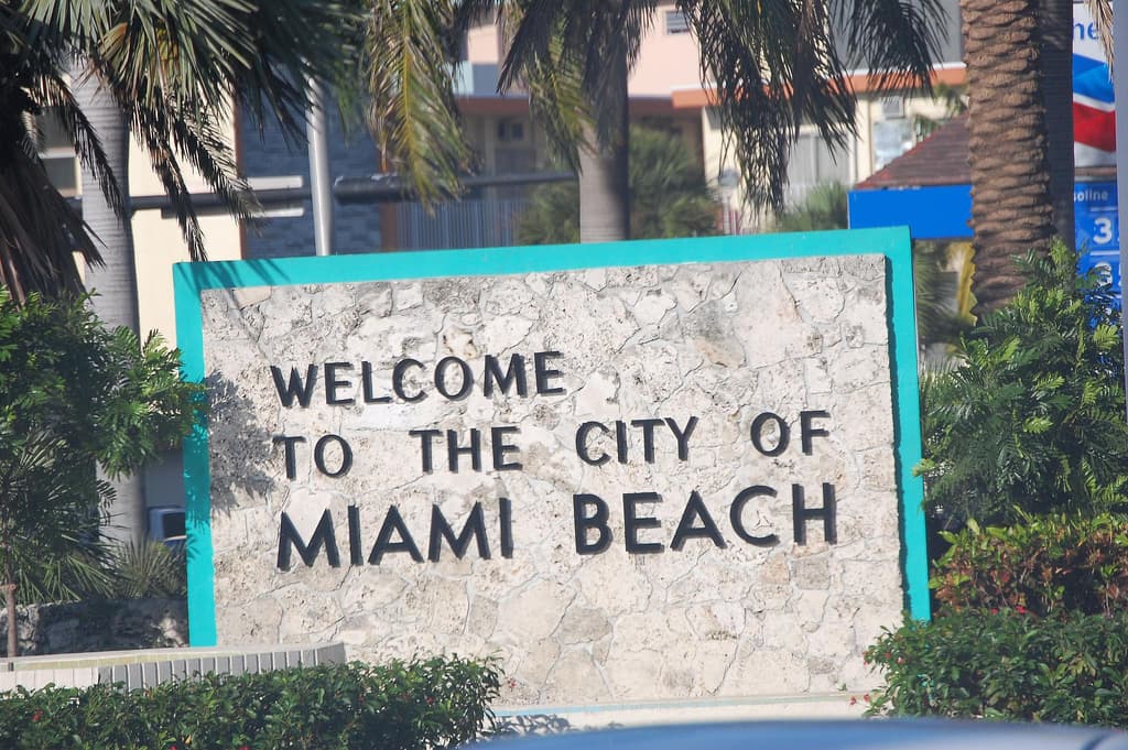 Cartel real de bienvenida a Miami Beach entre palmeras